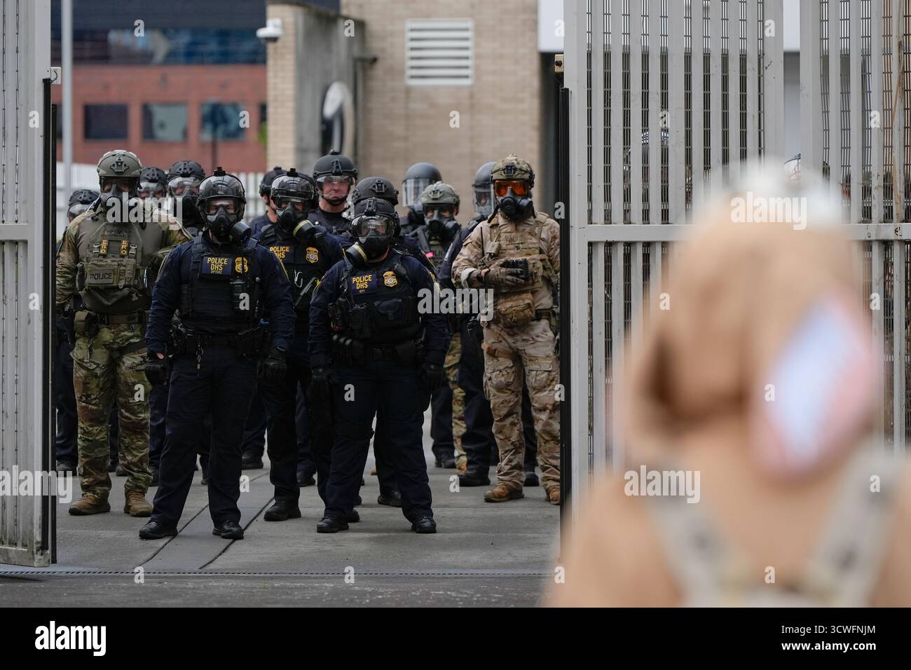 Law enforcement officers watch as the gates close at a U.S. Immigration ...