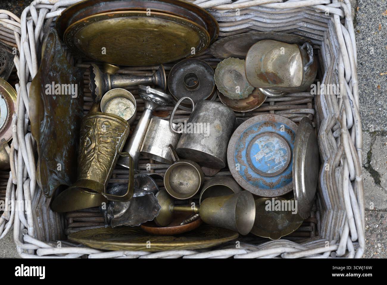 Basket of pewter and brass objects Stock Photo