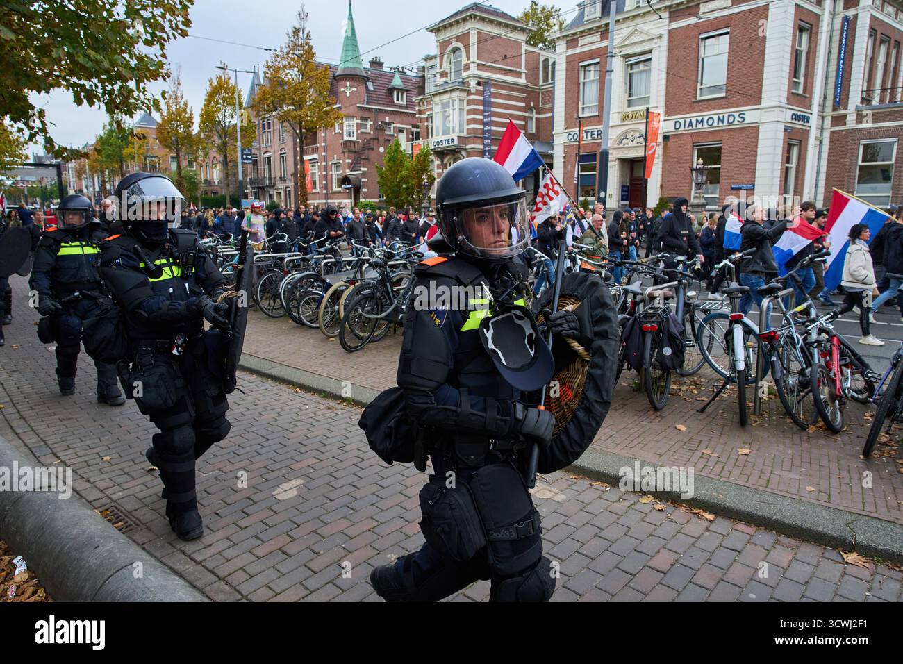 Dutch riot police escort anti-immigration protesters during a ...