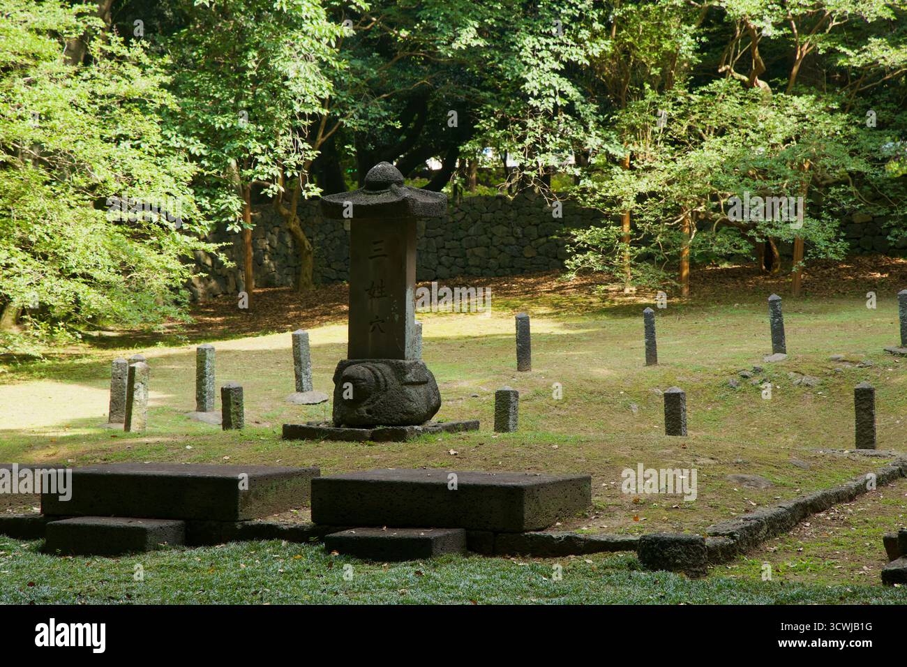 A closer view shows the turtle?base stele and surrounding posts in the shrine��s grassy depression, with the stone wall and trees behind. Stock Photo