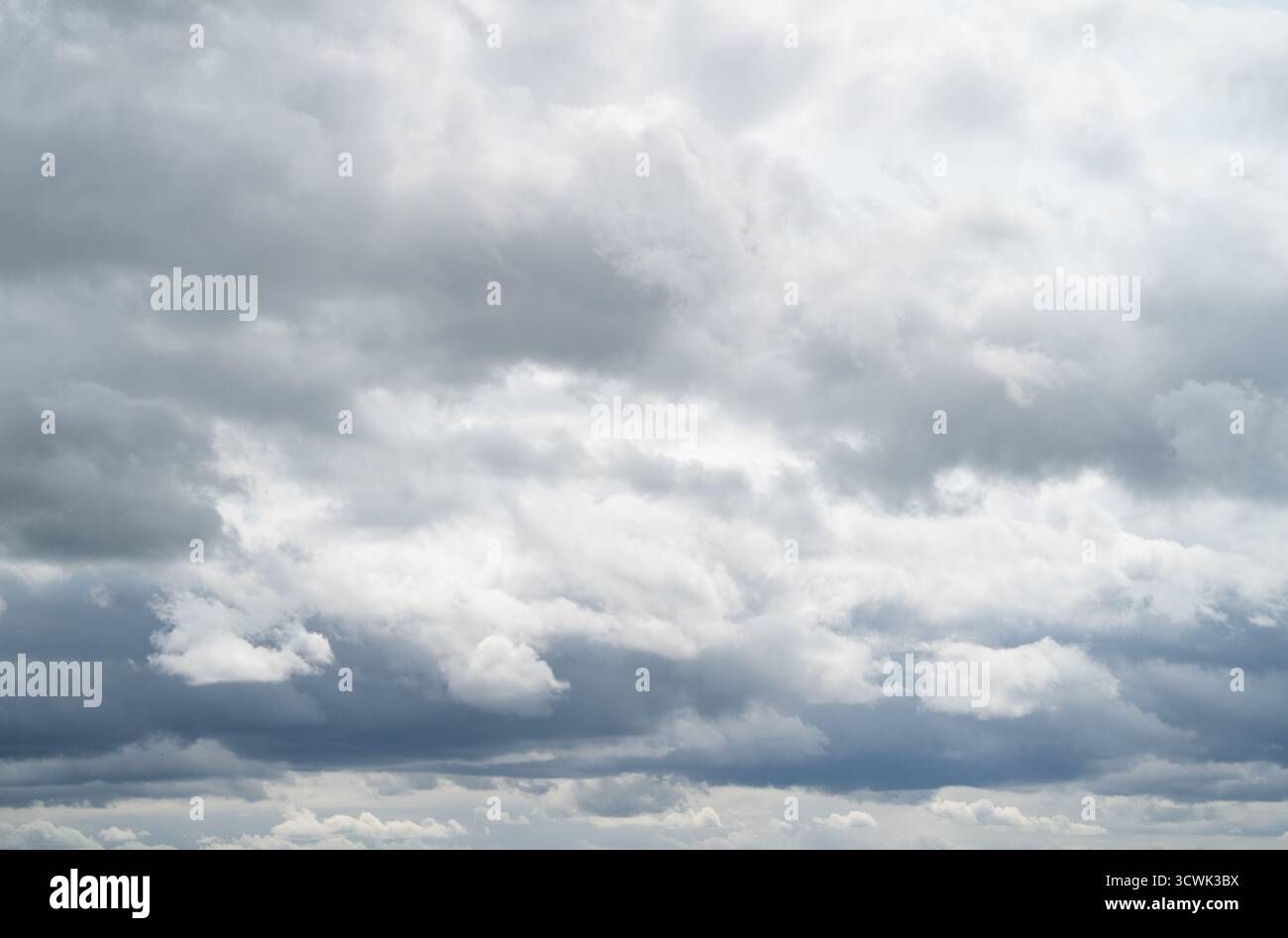Dramatic cloudy sky with grey and white cumulus clouds on overcast day Stock Photo