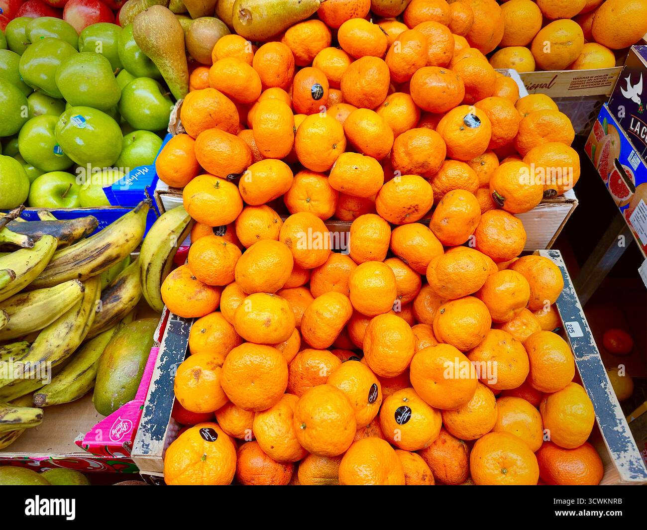Fresh oranges are piled high among other colorful fruits in a vibrant market display showcasing nature's bounty Tenerife Canaries - Smartphone Captured Stock Image