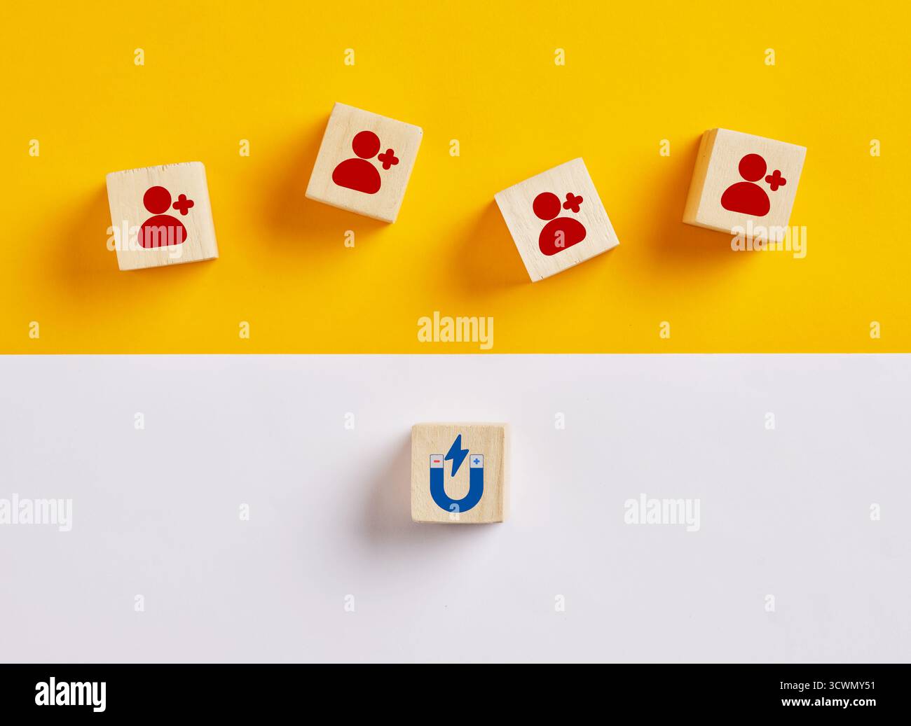 Wooden cubes with customer icons and magnet attracting them, representing attracting customers and leads Stock Photo