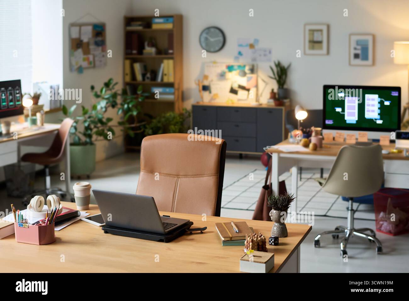 Modern Office Workspace Featuring Laptops and Digital Devices on Desks Stock Photo