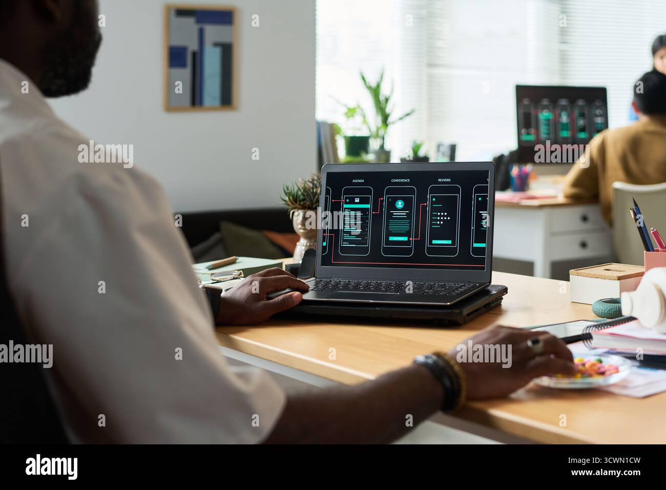 Black Man Developing Mobile Application Interface on Laptop Computer Stock Photo