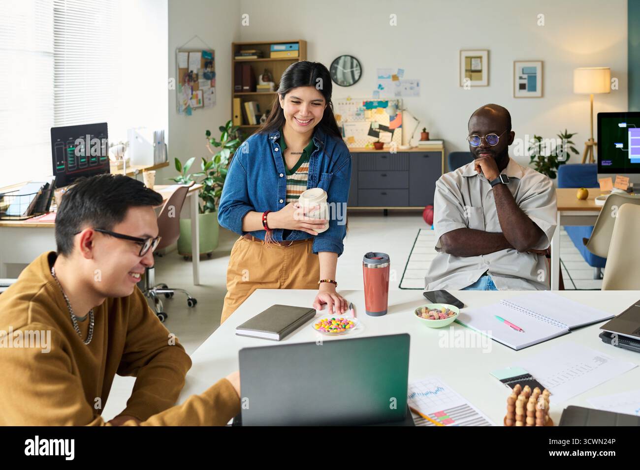Multiethnic Adults Collaborating on Project in Modern Office Workspace Stock Photo