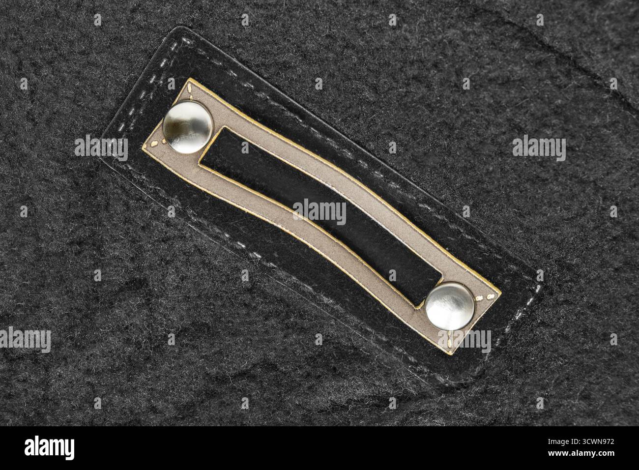 Empty clothes patch tag label stitched on black wool background Stock Photo