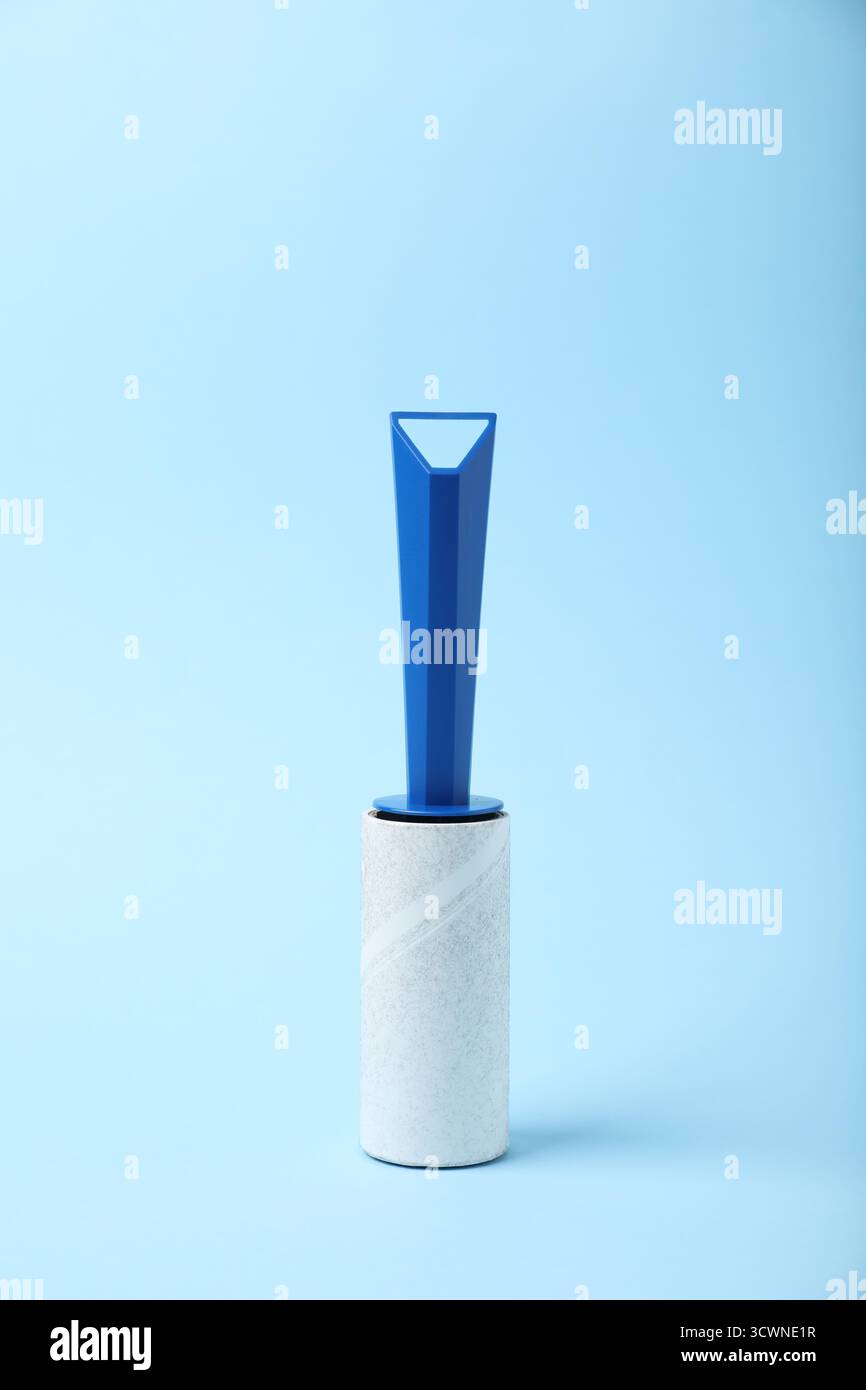 One lint roller on light blue background Stock Photo
