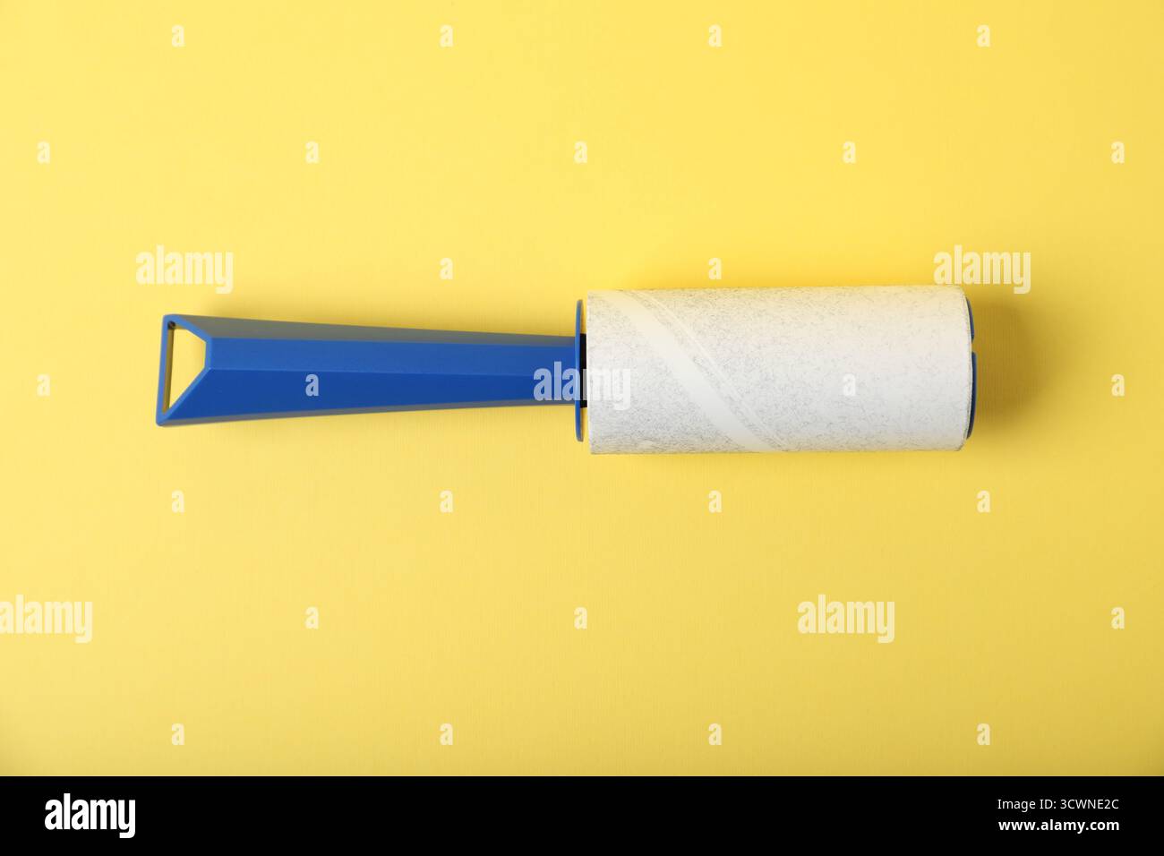 One lint roller on yellow background, top view Stock Photo