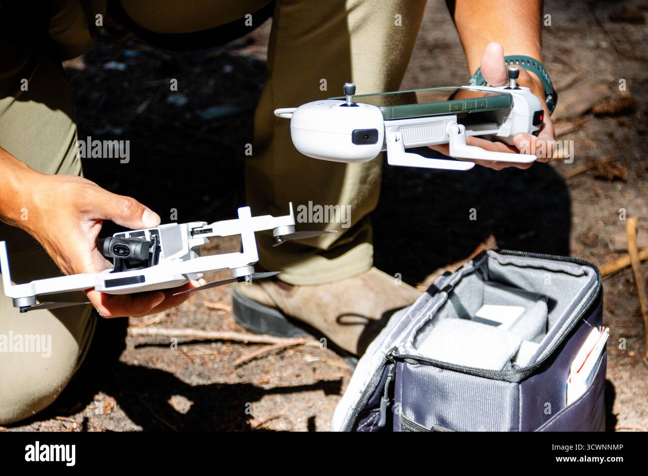 Man holding drone and controller in forest Stock Photo
