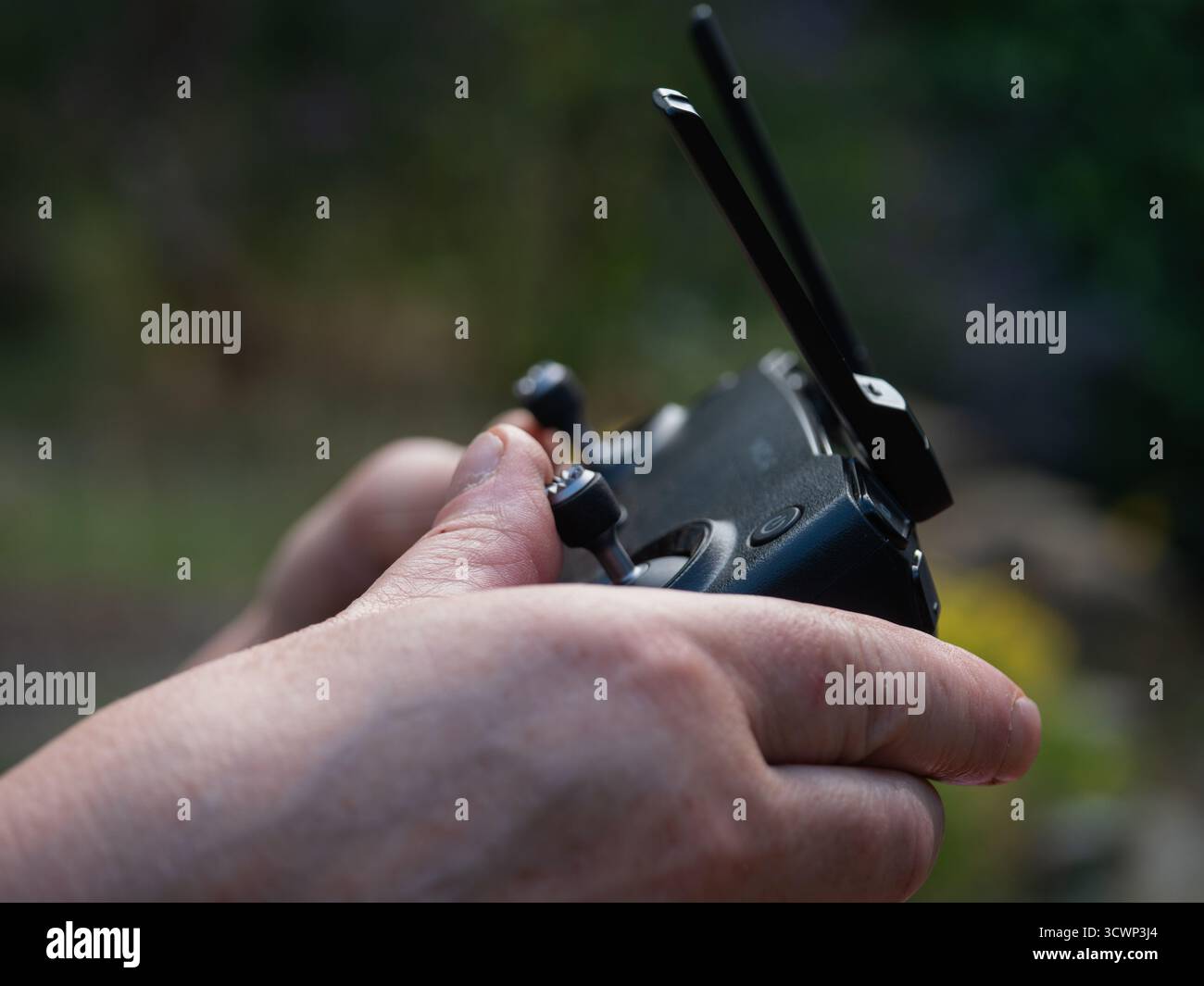 Hands with drone and remote controller in background  Stock Photo