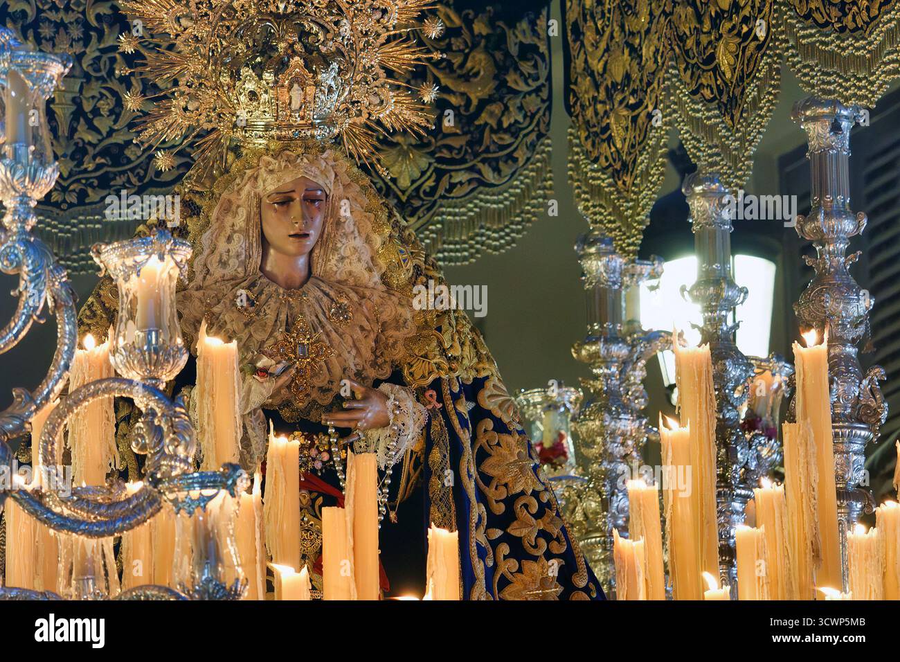 Front and close view of the Sorrowful Virgin on her processional throne, María Santísima del Gran Perdón. The light from the candles in the silver can Stock Photo