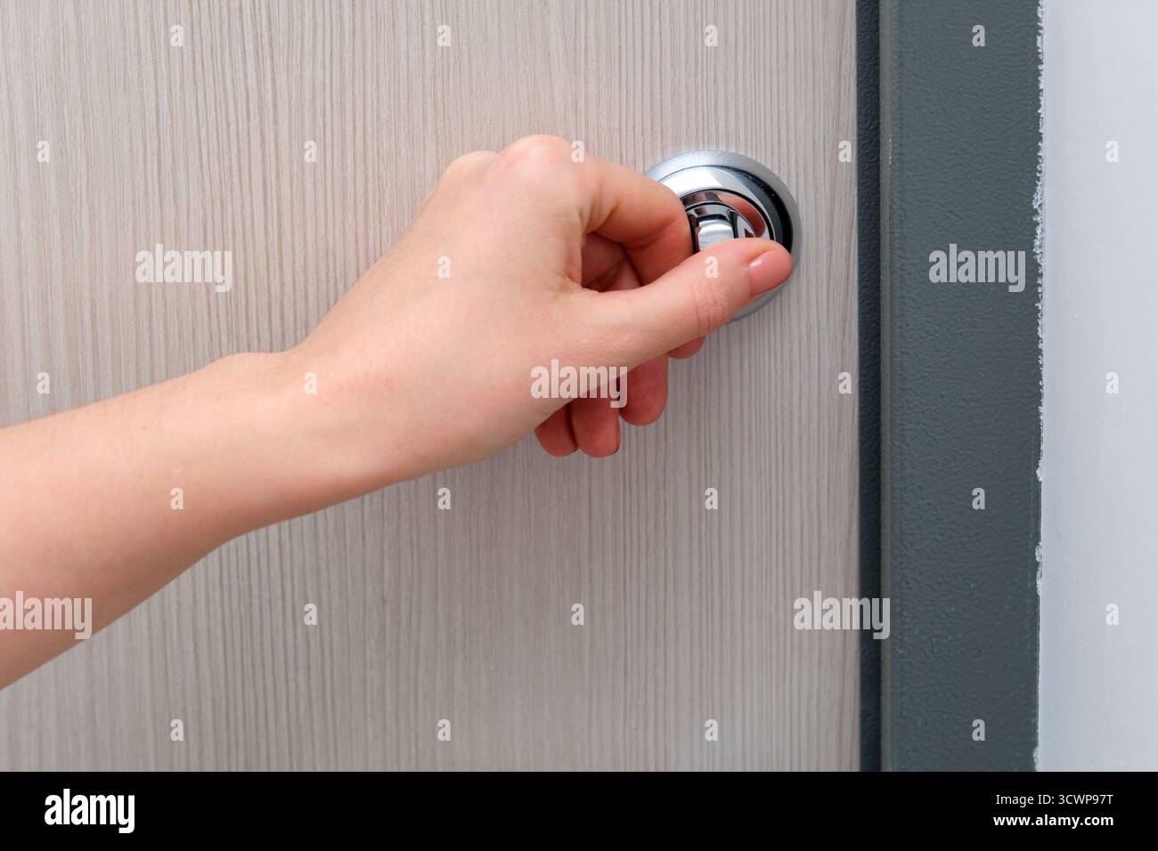 Woman hand pushing button on round door handle. Close up of female ...