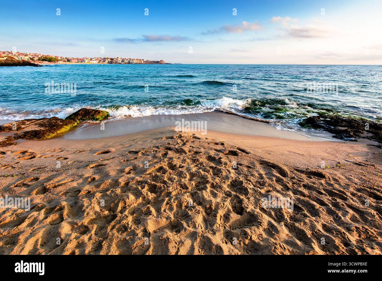 sunrise on a sandy town beach in mellow season. beautiful and warm weather on the shores of black sea. sozopol coast in morning light Stock Photo