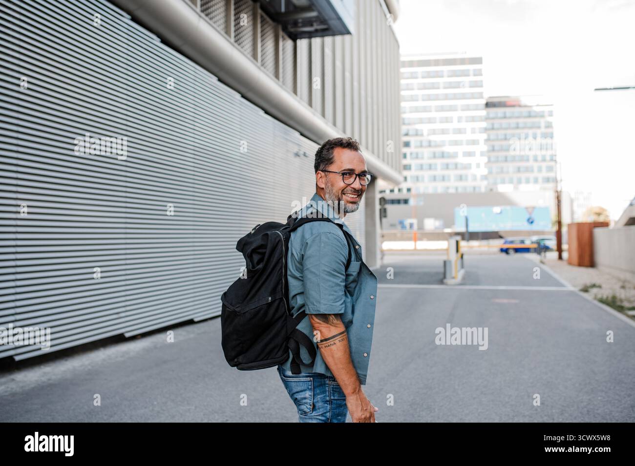 Handsome man with tattoos walking down the street. Stock Photo