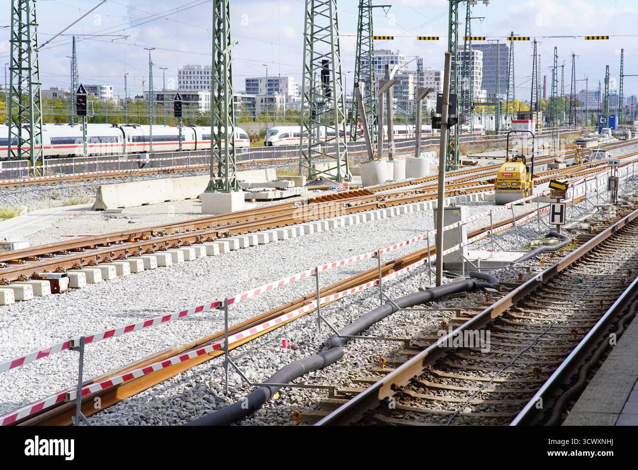 Railway maintenance and track construction on the Munich S-Bahn network with overhead wires and city buildings in the background.Munich,Germany Stock Photo