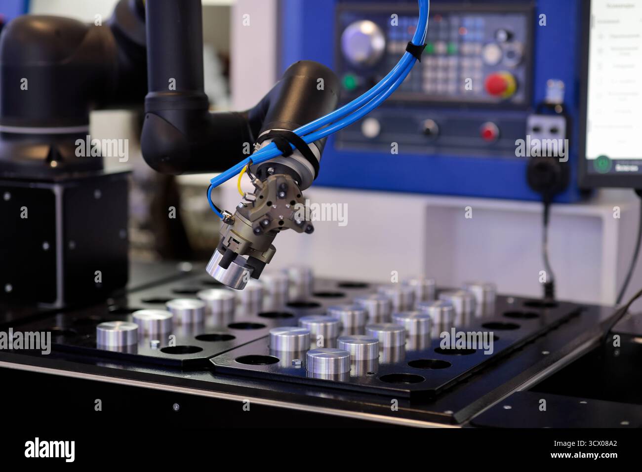 Robot manipulator loads workpiece in CNC machine. Selective focus. Stock Photo