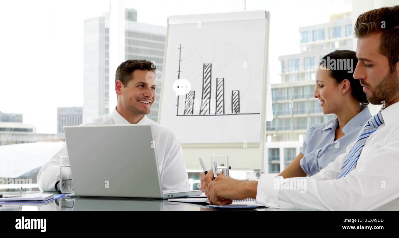 Middle Eastern man presenting to colleagues in meeting room, with flip chart, laptop, copy space Stock Photo