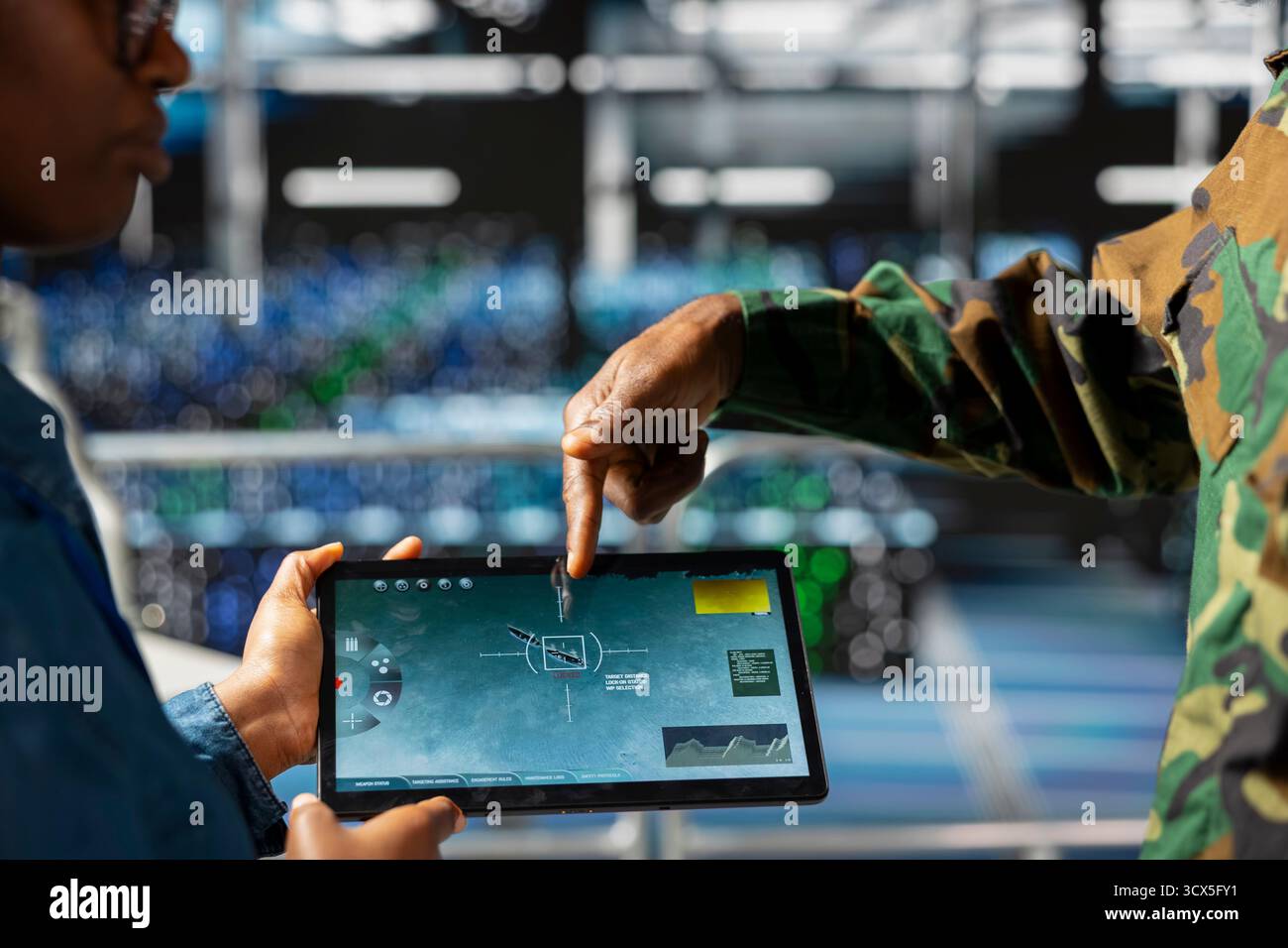 Military technician reviewing tactical dashboard on tablet screen in ...