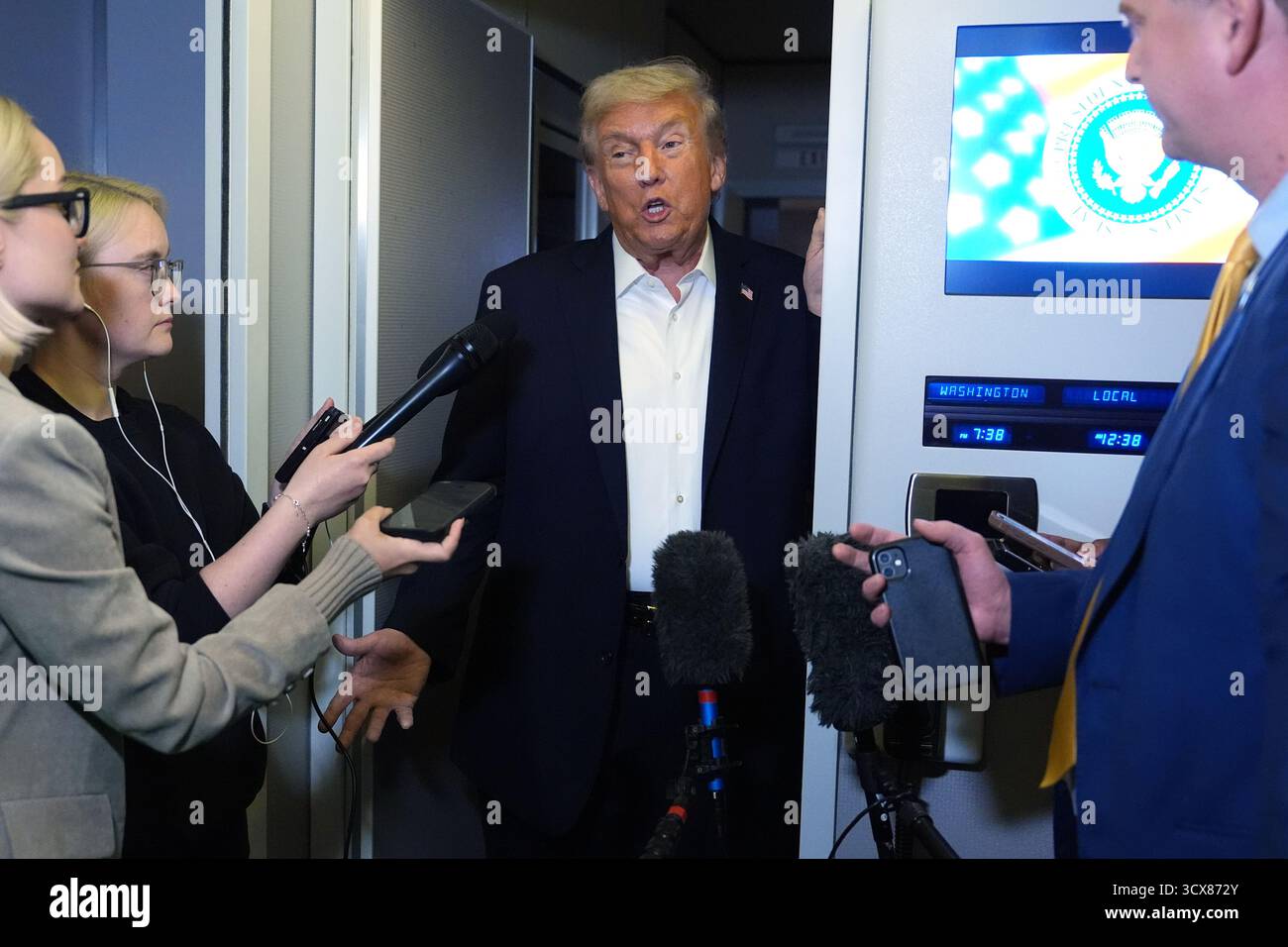 President Donald Trump speaks to reporters aboard Air Force One during ...