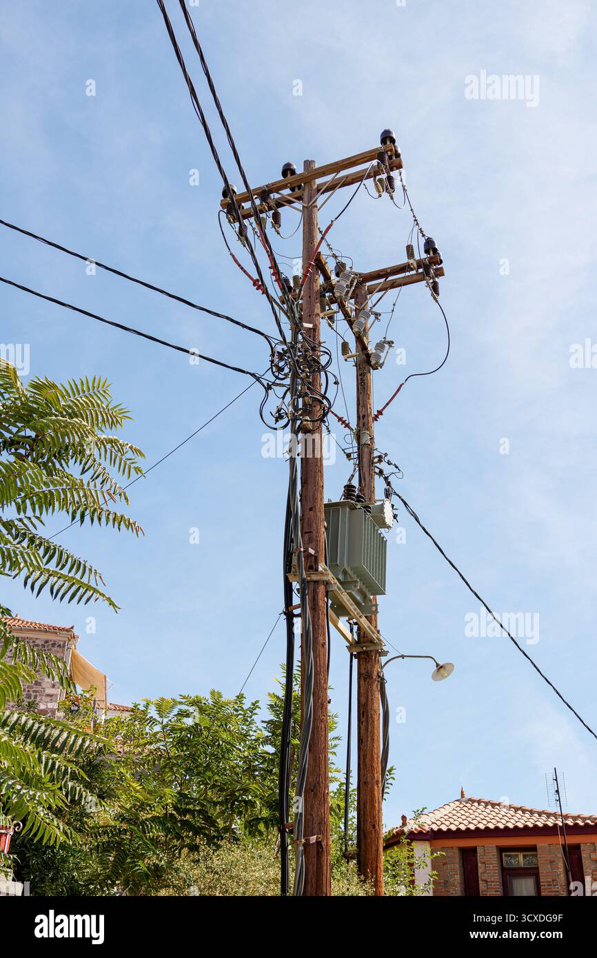 Wooden utility poles with electrical wires against blue sky Stock Photo ...