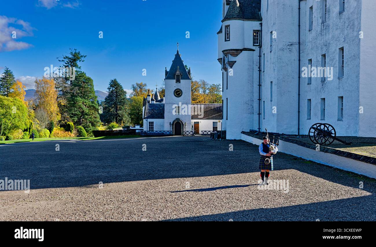 Blair Castle Perthshire Scotland lone piper playing the bagpipes and trees in Autumn Stock Photo