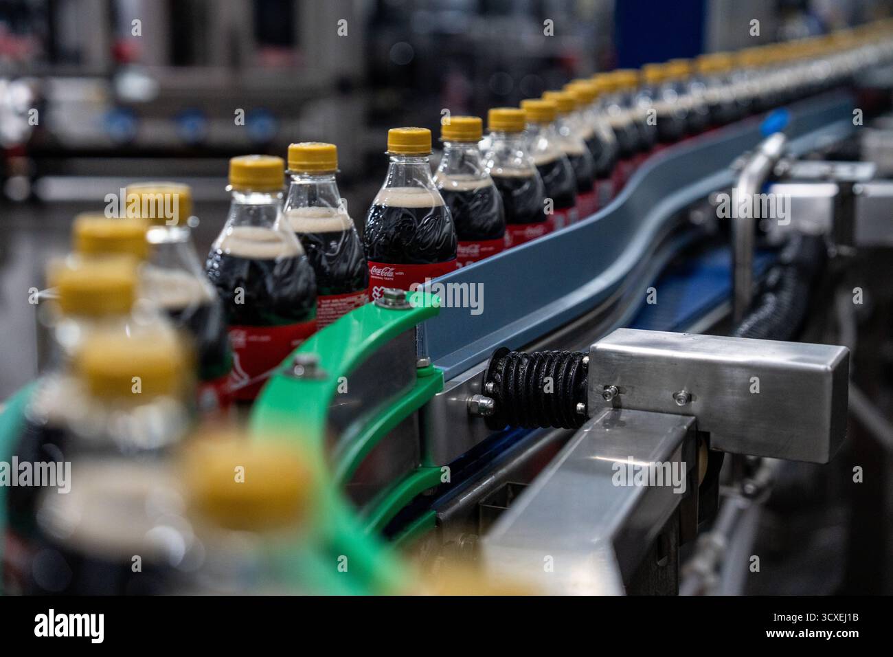 Bottles of Coca-Cola moving on a production line at the Swire Coca-Cola ...