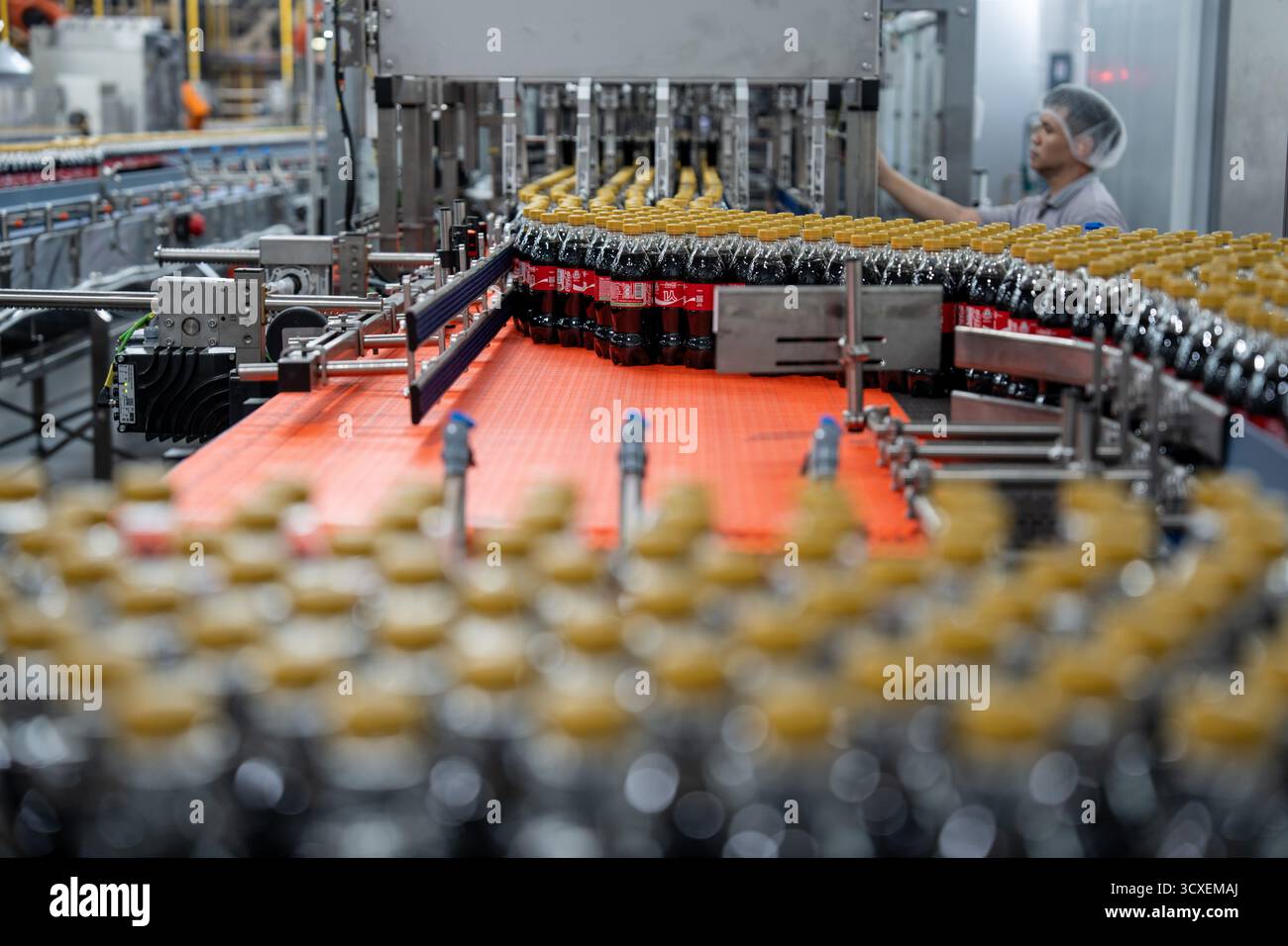 Bottles of Coca-Cola moving on a production line at the Swire Coca-Cola ...