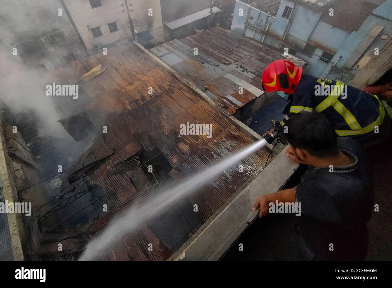 A firefighter sprays water to douse the flames after a fire broke out ...