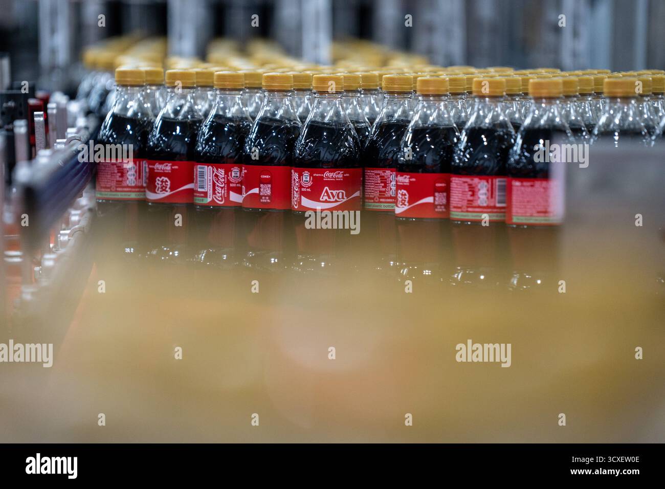 Bottles of Coca-Cola moving on a production line at the Swire Coca-Cola ...