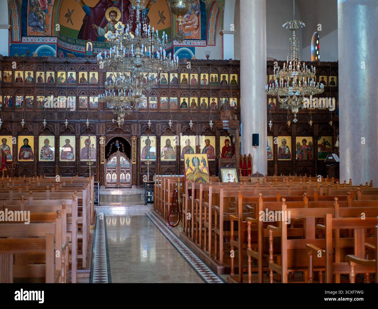 The interior of a church features icons and wooden benches, creating a ...