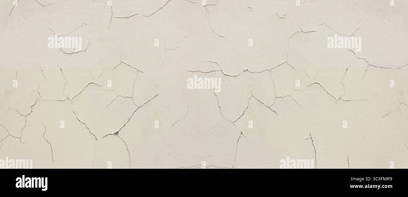 Cracked peeling white paint creating abstract wall texture Stock Photo