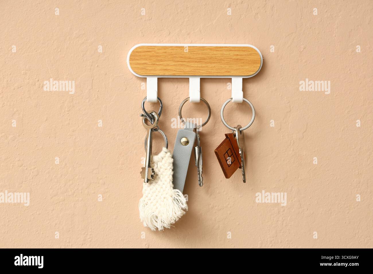 Rack with keys from house on beige wall Stock Photo