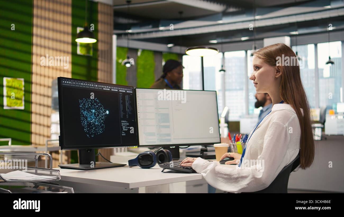 Female technician testing generative AI machine learning algorithms at work. IT professional scaling productivity with artificial intelligence large language model written code, camera A Stock Photo