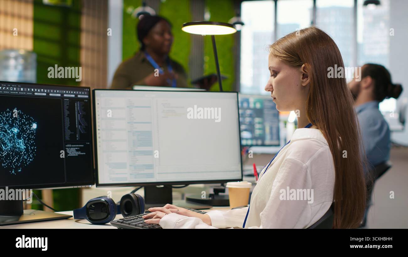 Female technician testing generative AI machine learning algorithms at work. IT professional scaling productivity with artificial intelligence large language model written code, camera A Stock Photo
