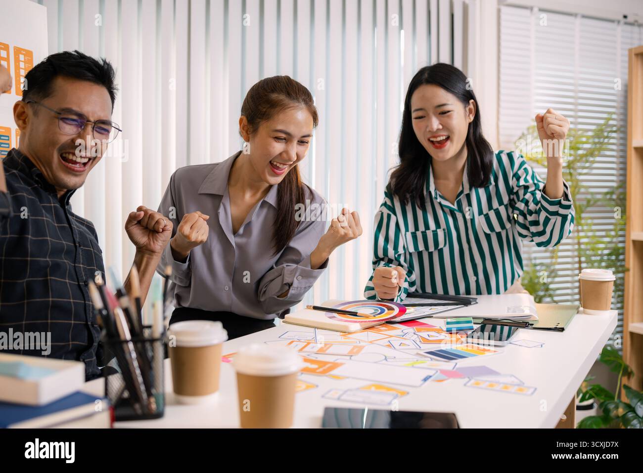 UX/UI designers collaborating during a creative workshop to test interface ideas and exchange feedback for app development, emphasizing teamwork and i Stock Photo