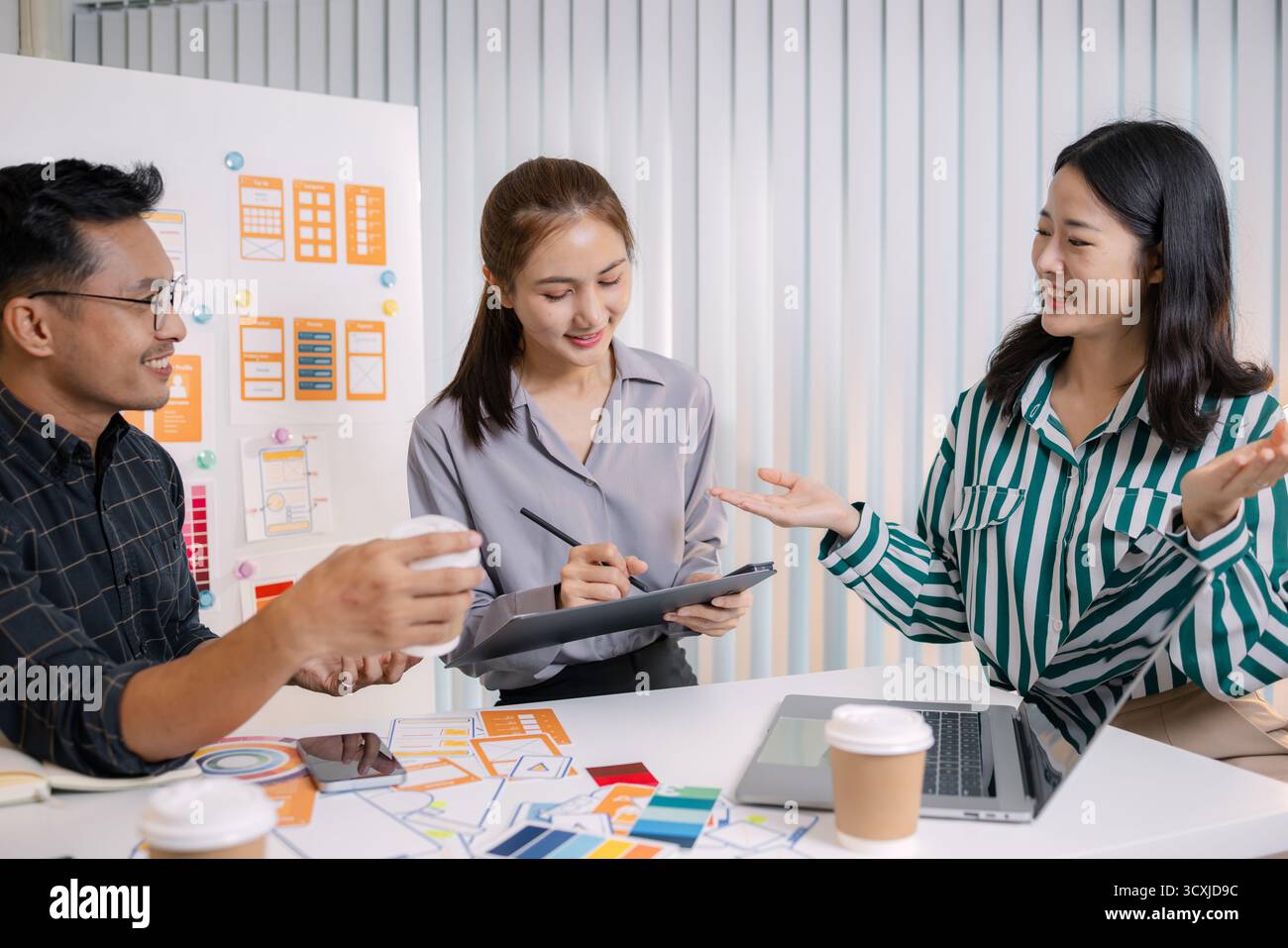 UX/UI designers collaborating during a creative workshop to test interface ideas and exchange feedback for app development, emphasizing teamwork and i Stock Photo