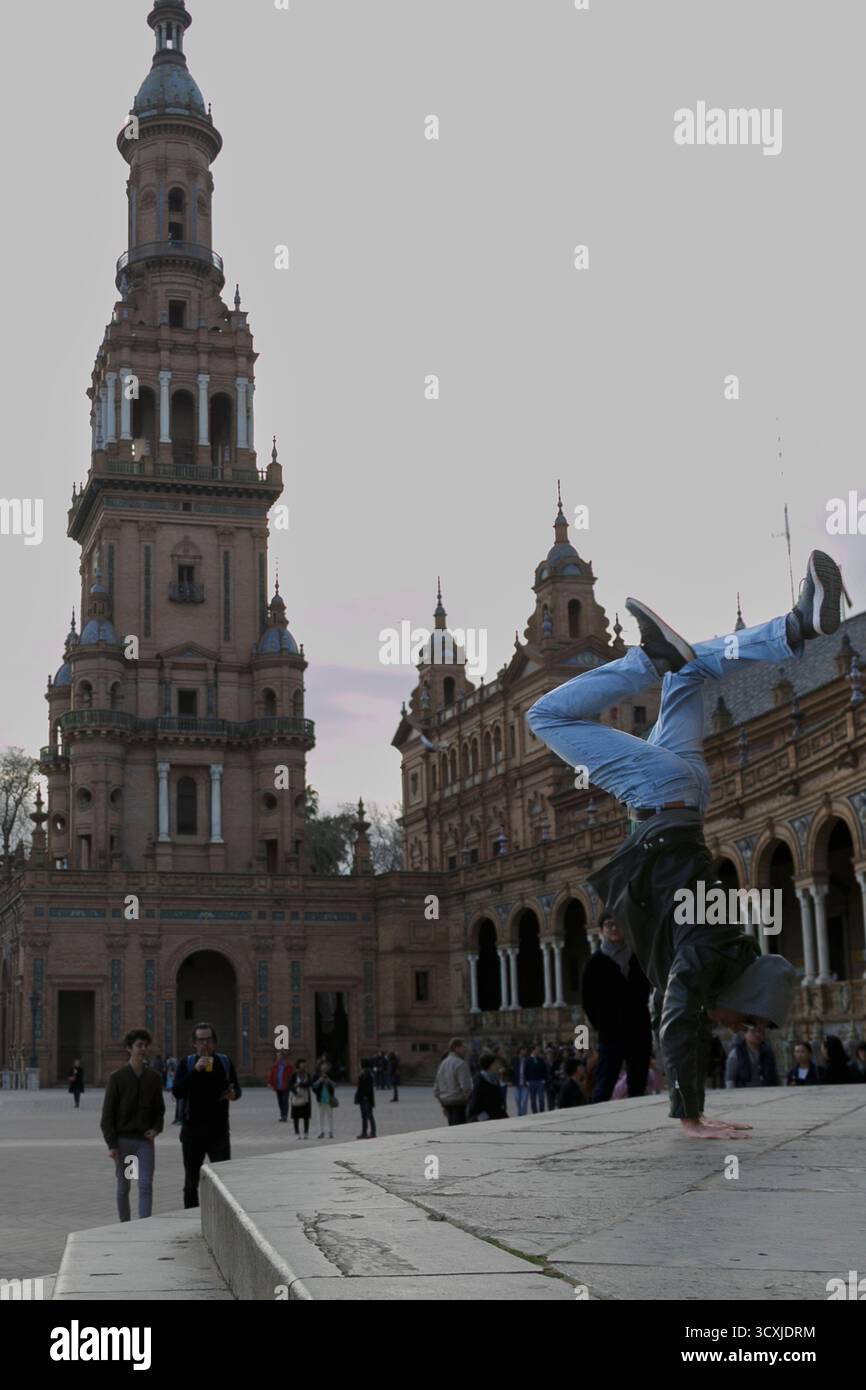 A talented breakdancer passionately showcases impressive and energetic moves against a stunning architectural backdrop Stock Photo