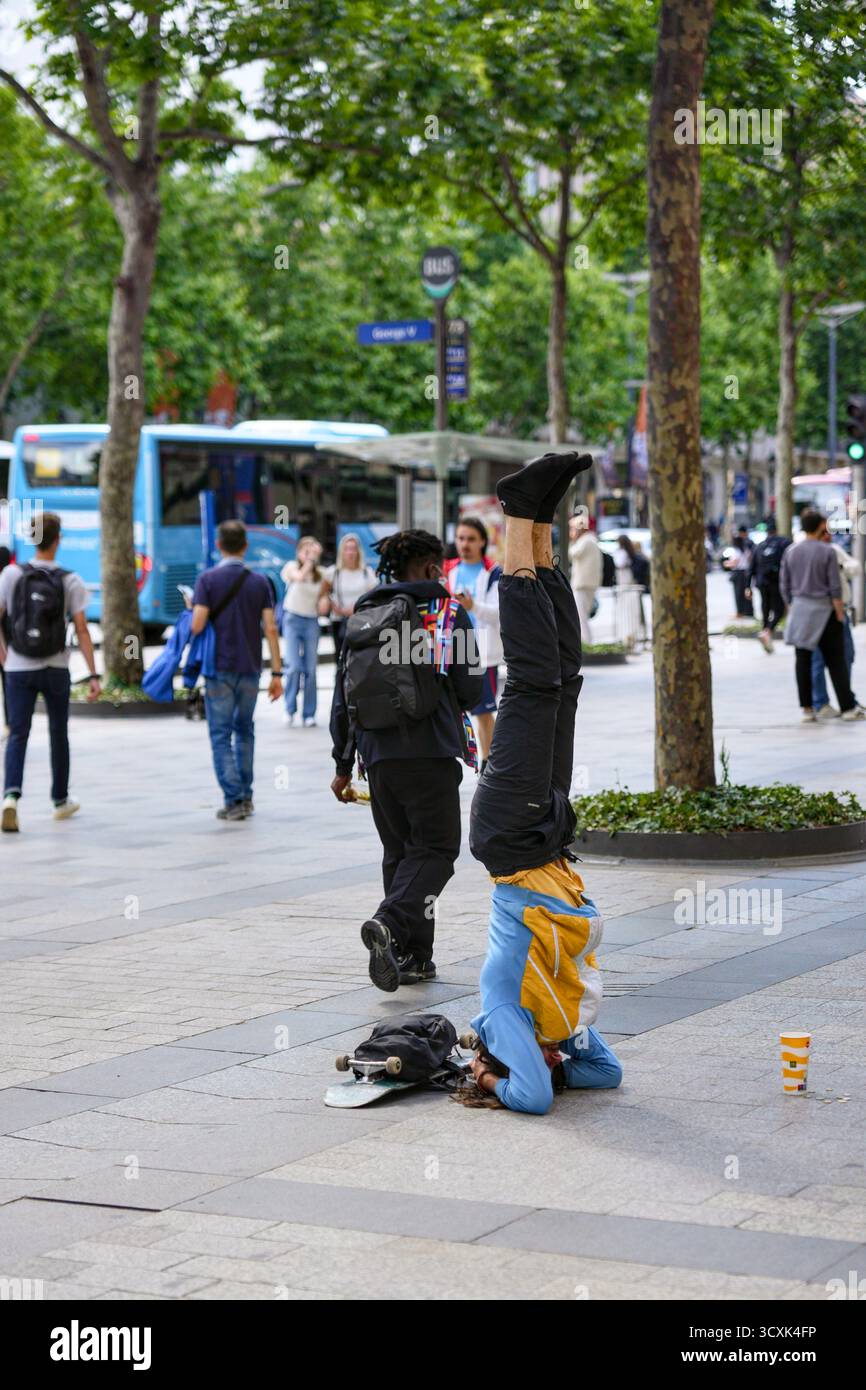 Street performer doing headstand in Paris, France, June 2, 2025 Stock Photo