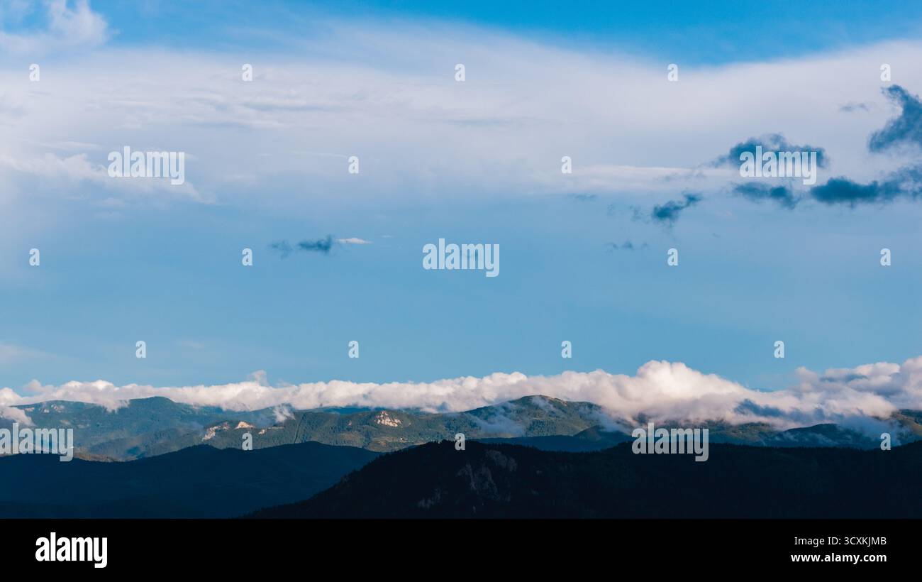 Panoramic mountain landscape under blue sky with scattered clouds Stock Photo