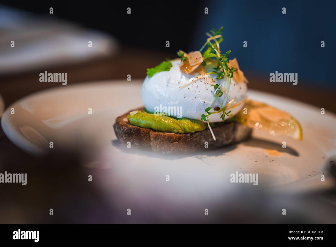 Close up plated avocado toast with poached egg in Japan restaurant Stock Photo
