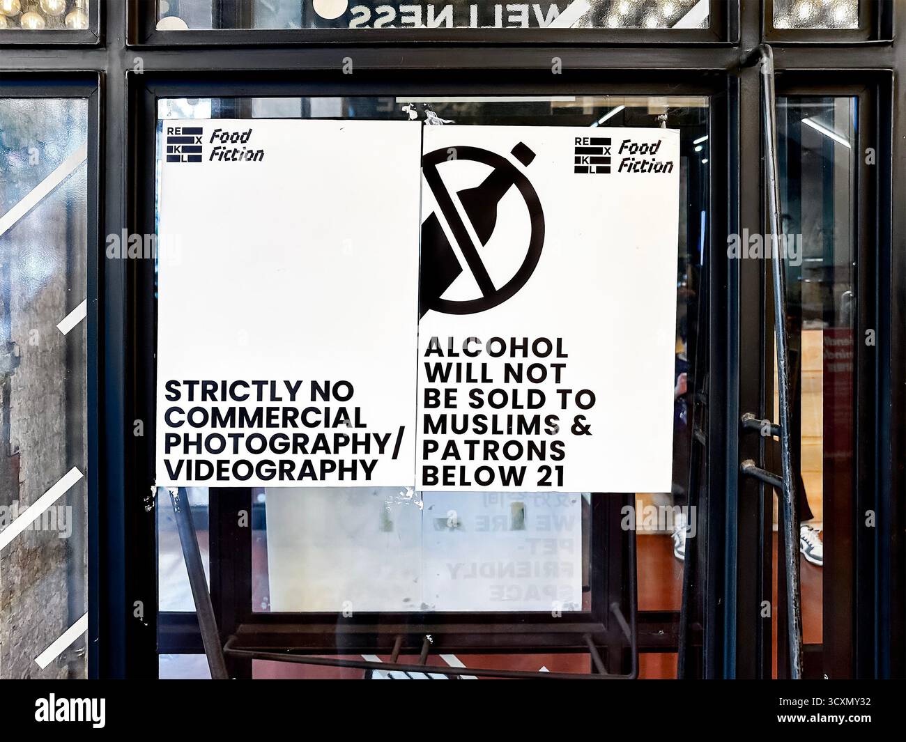 Sign at venue entrance prohibiting commercial photography & sale of alcohol to patrons below 21, muslims black & white notice in kuala lumpur malaysia - Smartphone Captured Stock Image