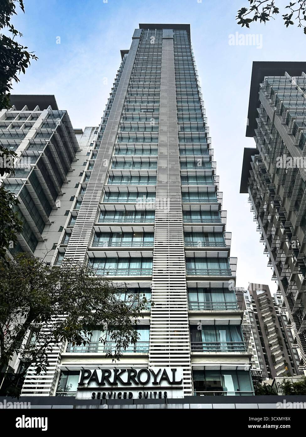 looking up Tall modern skyscraper park royal hotel & serviced apartments kuala lumpur malaysia with glass facade surrounded by high-rise buildings - Smartphone Captured Stock Image