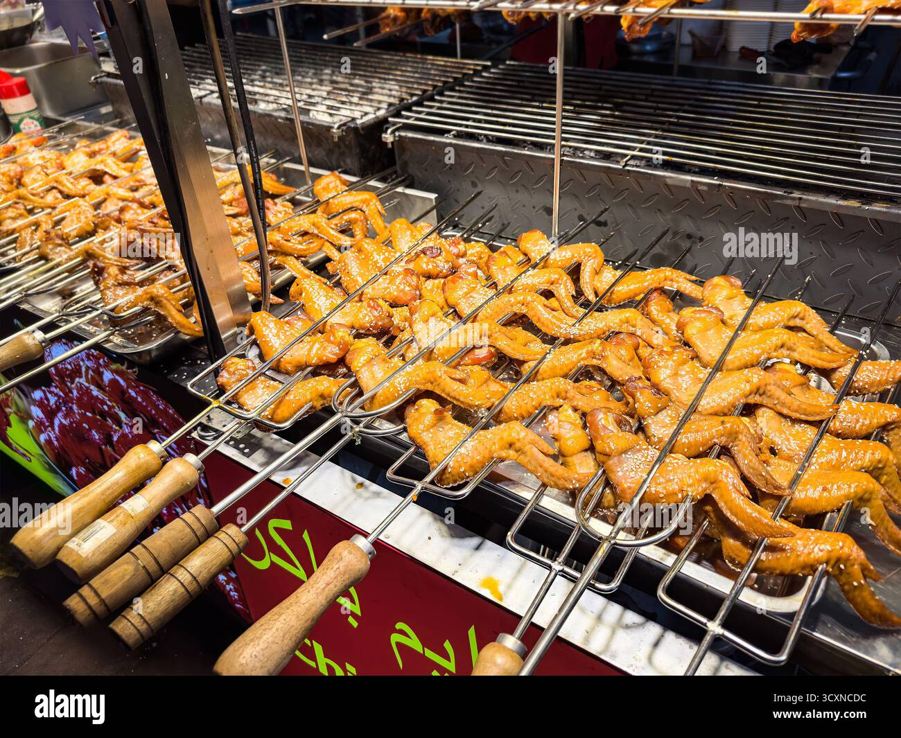 Grilled skewered chicken wings cooking busy Jalan alor street food market delicious Asian cuisine & culinary traditions kuala lumpur malaysia - Smartphone Captured Stock Image
