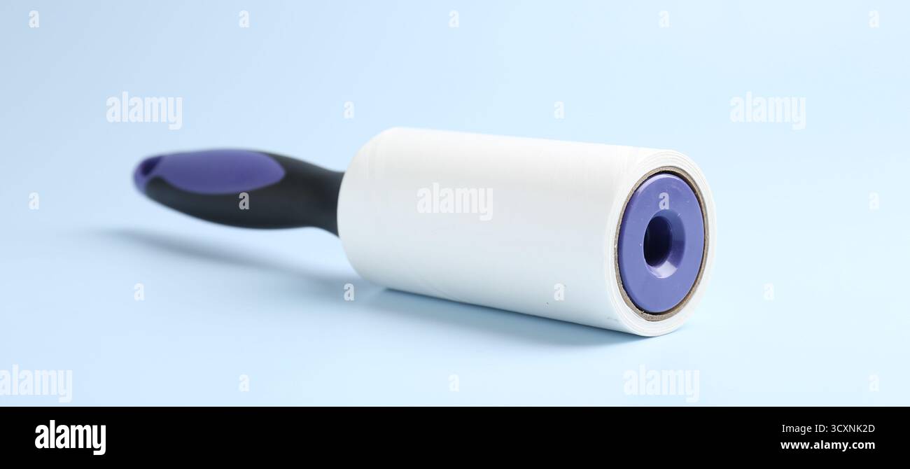 One lint roller on light blue background, closeup Stock Photo