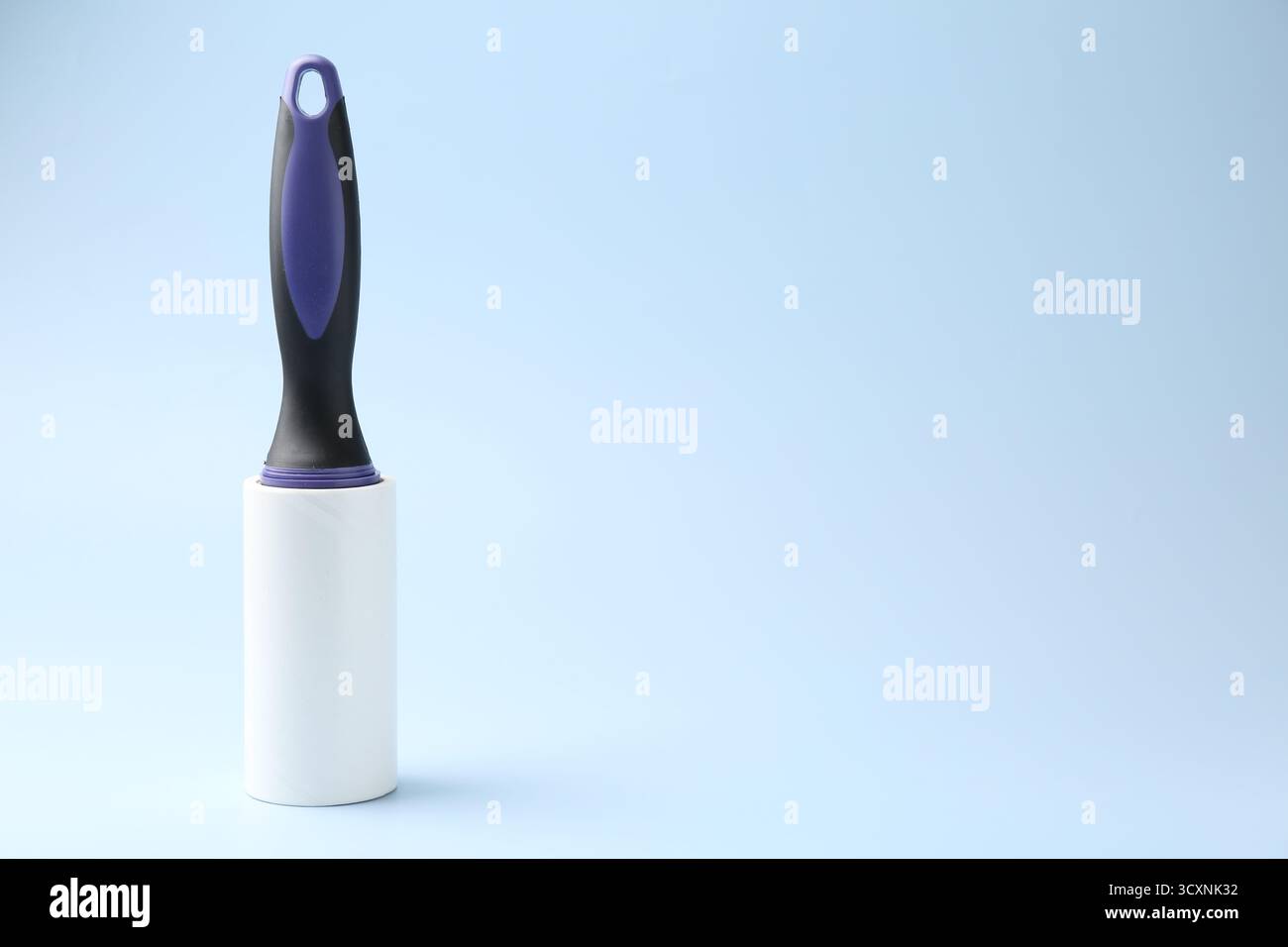 One lint roller on light blue background, space for text Stock Photo