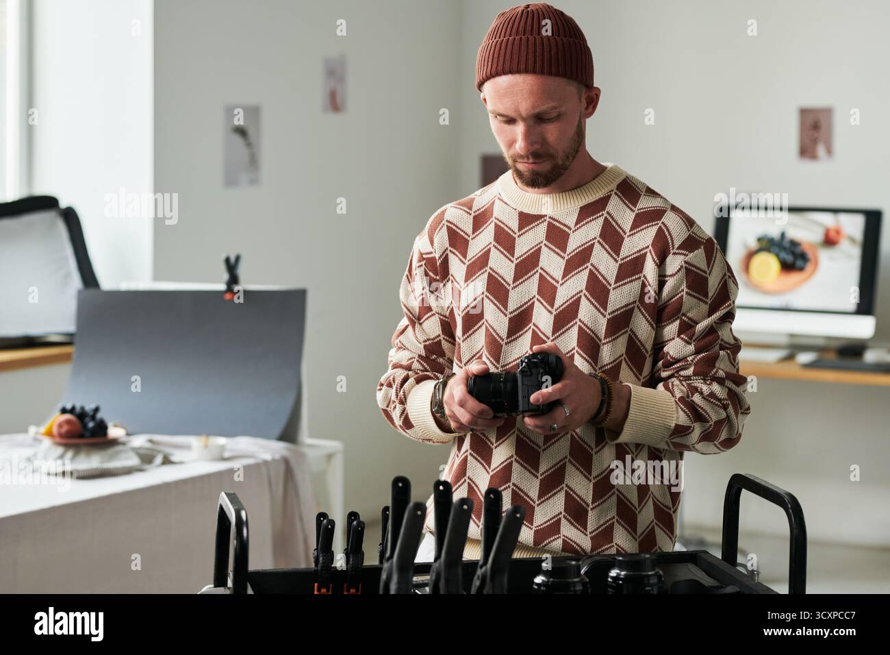 Man Adjusting Camera Settings in Professional Studio Stock Photo