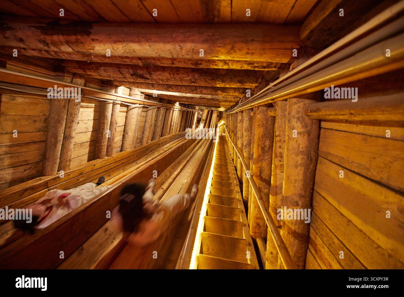 Person sliding to the lower level in the Hallstatt salt mine, Austria Stock Photo