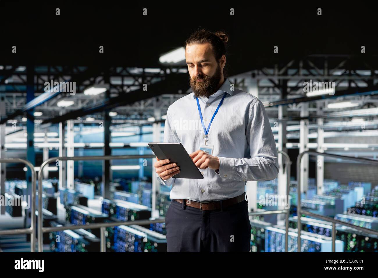 System administrator on data center industrial platform checking code on tablet, managing software updates for server rigs configuration. Male IT professional ensuring data management. Stock Photo