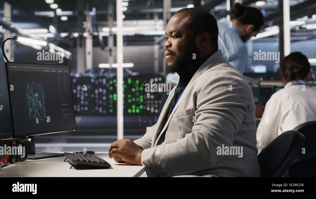 Exhausted server farm employee stretching back after sitting too long ...